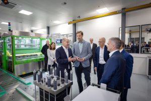 Das Bild zeigt die Eröffnung des Quest-One-Standorts in Hamburg, es ist unter anderem Bundeskanzler Olaf Scholz zu sehen.