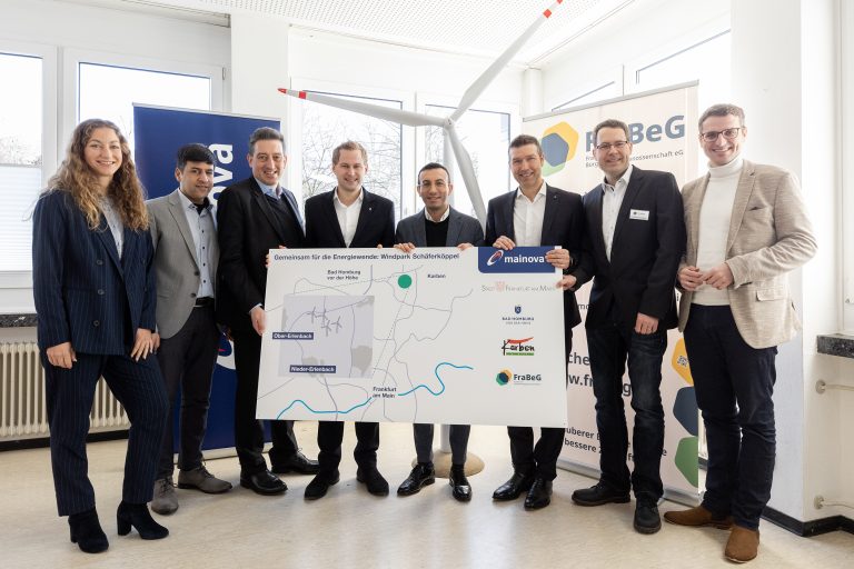 Gruppenfoto von acht Personen bei der Vorstellung des geplanten Windparks Schäferköppel. Von links: Tina Zapf Rodriguez (Frankfurter Dezernentin für Klima, Umwelt und Frauen), Thomas Schrage (Erster Stadtrat Karben), Dr. Michael Maxelon (Vorstandsvorsitzender Mainova AG), Dr. Oliver Jedynak (Bürgermeister Bad Homburg vor der Höhe), Mike Josef (Oberbürgermeister Frankfurt am Main), Martin Giehl (Vorstand Technik & Erzeugung Mainova AG), Christian Stenglein (Vorstandsmitglied FraBeG) und Yannick Schwander (Ortsvorsteher Nieder-Erlenbach). Die Gruppe hält eine große Standortkarte des Windparks; im Hintergrund stehen Roll-ups der beteiligten Organisationen und ein Modell eines Windrads.