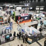 Blick von oben in eine Messehalle der GeoTHERM in Offenburg: Zahlreiche Aussteller präsentieren an hell beleuchteten Ständen Bohrtechnik, Geothermie- und Energielösungen, während Fachbesucherinnen und Fachbesucher zwischen den Ständen Gespräche führen.