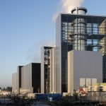 Gas- und Dampfkraftwerk der Stadtwerke Düsseldorf mit moderner Industriearchitektur, großem verglasten Turm und Schornstein auf dem Betriebsgelände bei Tageslicht.