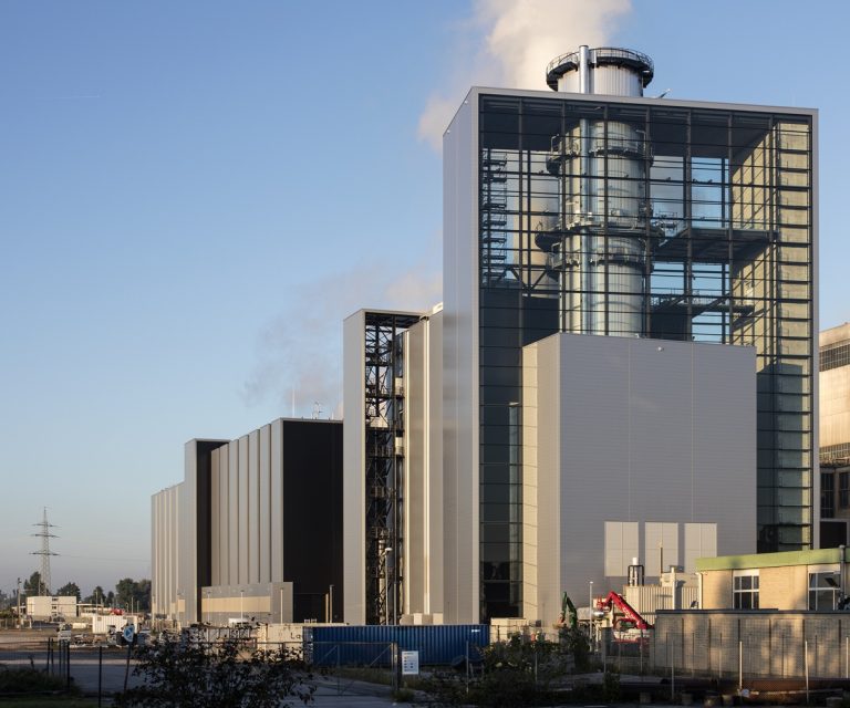 Gas- und Dampfkraftwerk der Stadtwerke Düsseldorf mit moderner Industriearchitektur, großem verglasten Turm und Schornstein auf dem Betriebsgelände bei Tageslicht.