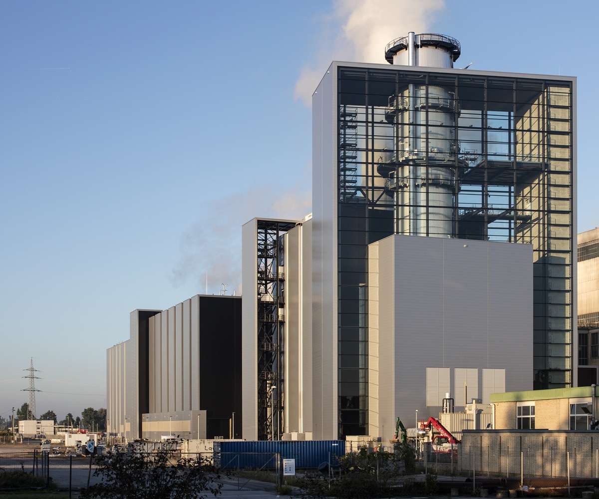 Gas- und Dampfkraftwerk der Stadtwerke Düsseldorf mit moderner Industriearchitektur, großem verglasten Turm und Schornstein auf dem Betriebsgelände bei Tageslicht.
