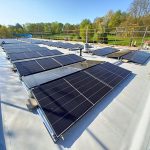 Photovoltaikanlage mit zahlreichen Solarmodulen auf dem Flachdach des Freibads der Stadt Alzey.