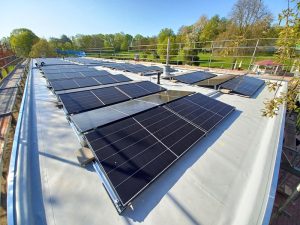 Photovoltaikanlage mit zahlreichen Solarmodulen auf dem Flachdach des Freibads der Stadt Alzey.