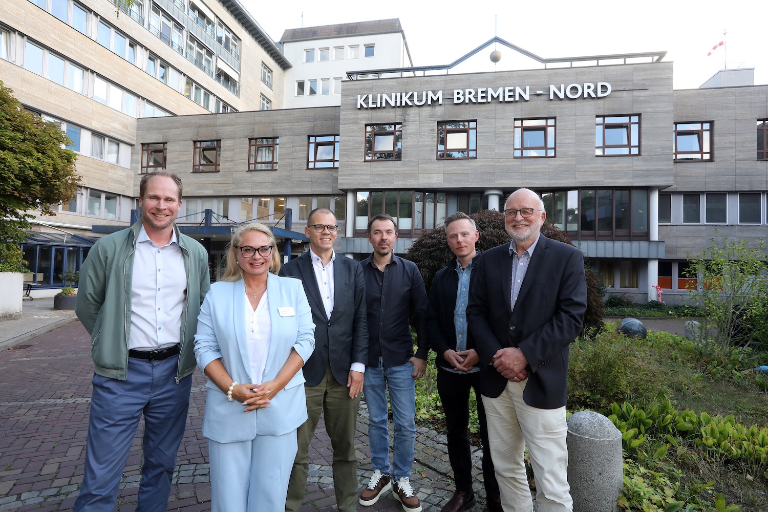 Gruppenfoto vor dem Klinikum Bremen-Nord. Von links: Sascha Brandt, Vertriebsleiter enercity contracting Nord, Vivien Voigt, geschäftsführende Krankenhausdirektorin, Jan Fries, Bremens Staatsrat für Umwelt, Klima und Wissenschaft, Eduard Gallwas, Objektleiter des Technik- und Gebäudemanagements im Klinikum Bremen-Nord, Dennis Witt, Projektleiter enercity contracting Nord, und Dr. Manfred Schüle, Geschäftsführer von enercity contracting.
